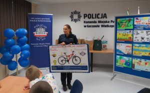 Policjantka omawia zasady bezpiecznego poruszania się rowerem.